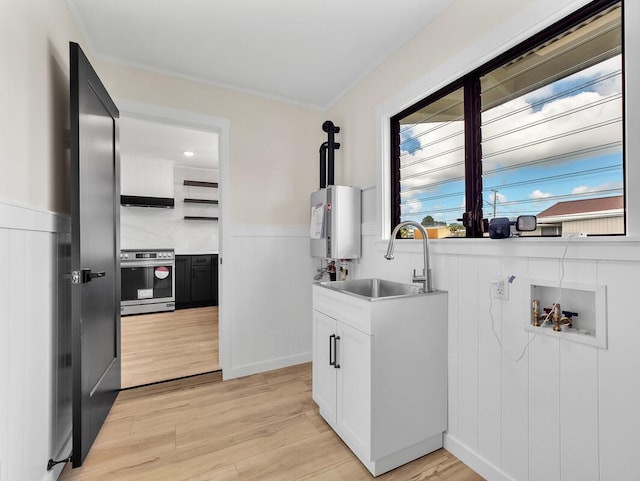 laundry room with light hardwood / wood-style floors, hookup for a washing machine, crown molding, water heater, and sink