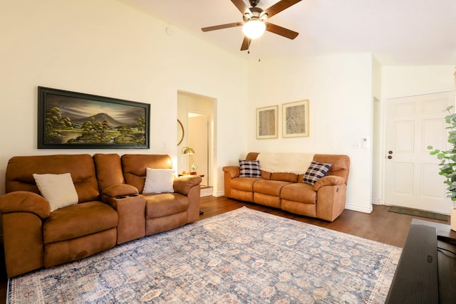 living room featuring dark hardwood / wood-style flooring, vaulted ceiling, and ceiling fan