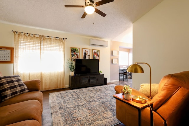 living room featuring lofted ceiling, a wall mounted air conditioner, a textured ceiling, and ceiling fan