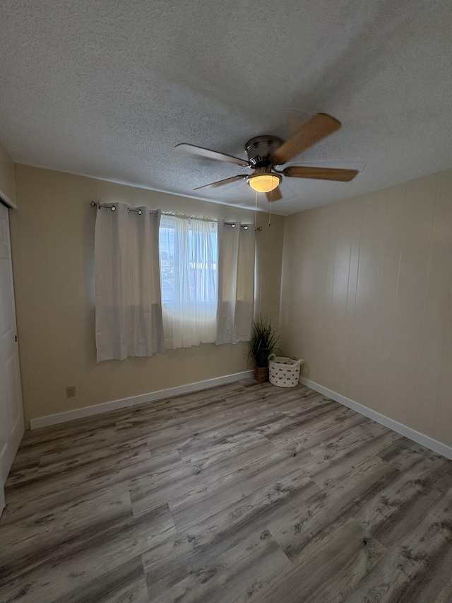 empty room featuring a textured ceiling, ceiling fan, and light hardwood / wood-style floors