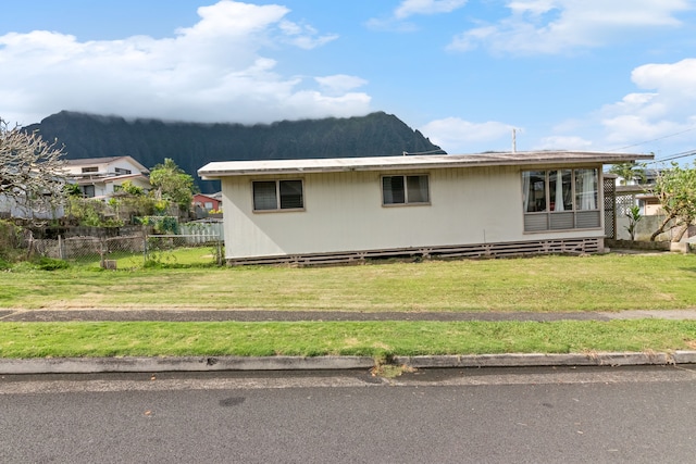 view of side of property with a lawn and a mountain view