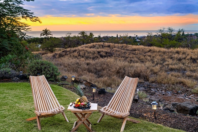 yard at dusk featuring a water view