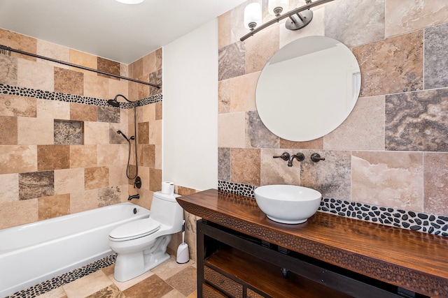 full bathroom featuring tiled shower / bath combo, vanity, tile walls, and toilet