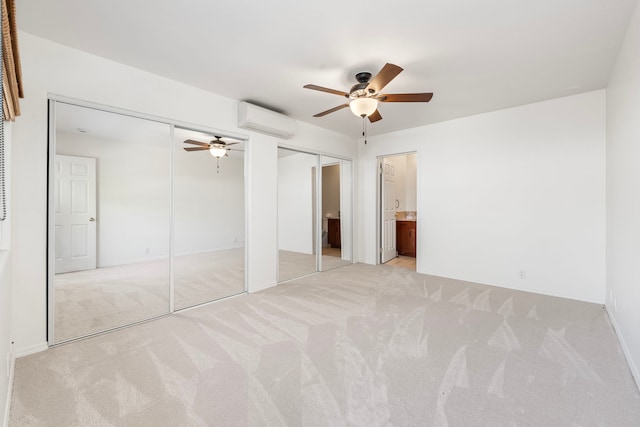 unfurnished bedroom with light carpet, two closets, an AC wall unit, and ceiling fan