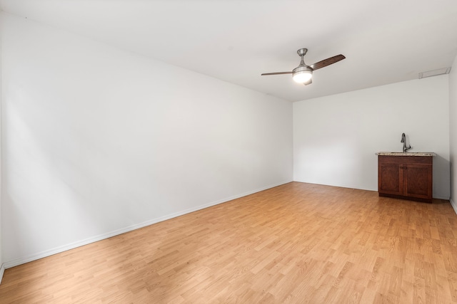 spare room featuring sink, ceiling fan, and light wood-type flooring