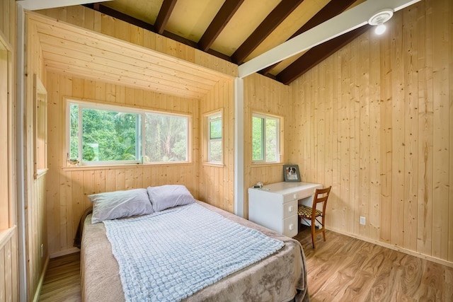 bedroom featuring lofted ceiling, light wood-type flooring, and multiple windows