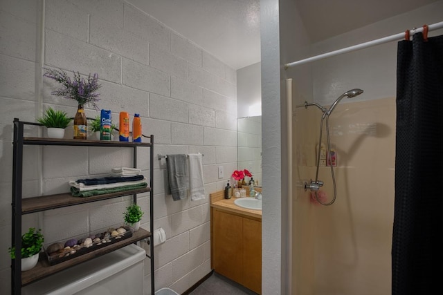 bathroom featuring toilet, walk in shower, and vanity