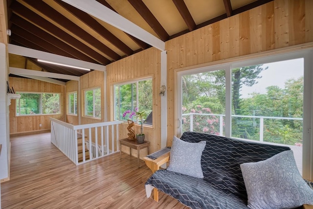 sunroom featuring a healthy amount of sunlight and lofted ceiling with beams