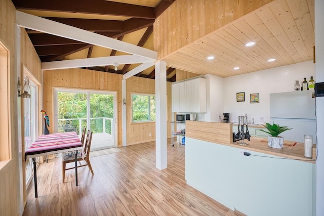 kitchen featuring vaulted ceiling with beams, wood ceiling, light hardwood / wood-style flooring, and white cabinets