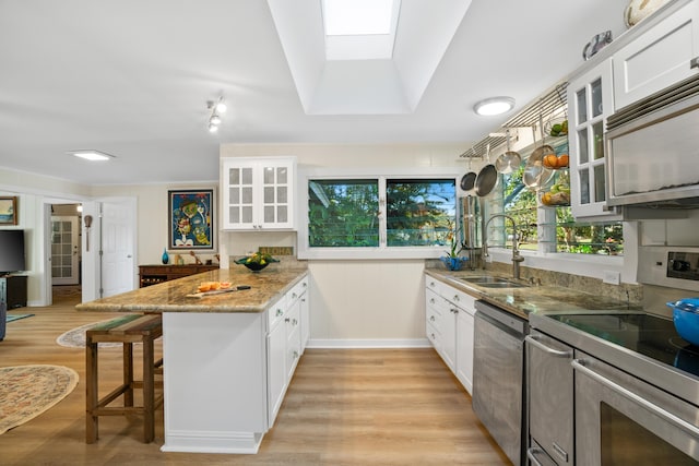 kitchen featuring white cabinetry, stainless steel appliances, and kitchen peninsula