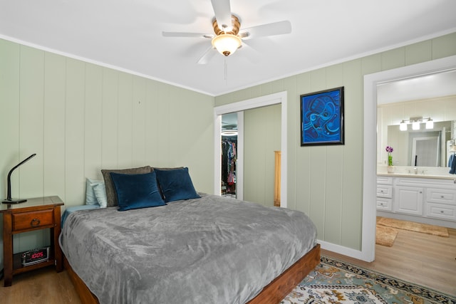 bedroom featuring ornamental molding, wood-type flooring, and a closet