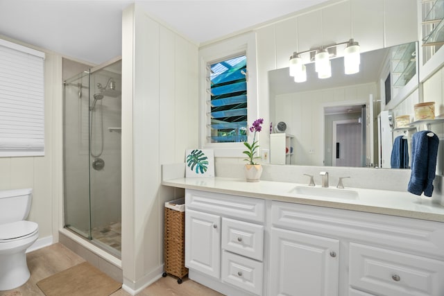 bathroom with hardwood / wood-style flooring, toilet, vanity, and a shower with shower door