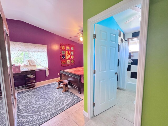 corridor featuring light tile patterned flooring and vaulted ceiling