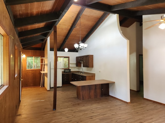 kitchen featuring a peninsula, wooden ceiling, a sink, and freestanding refrigerator