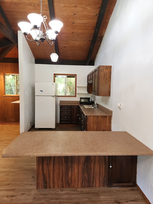 kitchen featuring vaulted ceiling with beams, wooden ceiling, a sink, and freestanding refrigerator