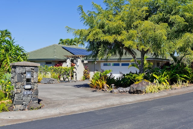 view of front facade featuring a garage and solar panels