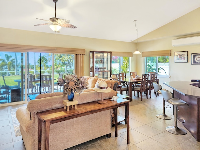 living room with a wealth of natural light, light tile patterned flooring, an AC wall unit, and vaulted ceiling