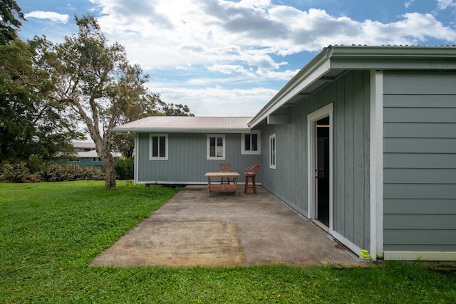 back of property with a yard and a patio area