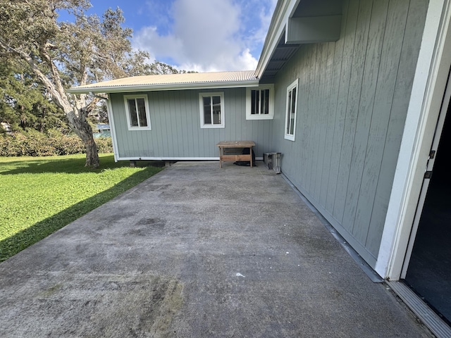 view of side of property featuring a yard and a patio area