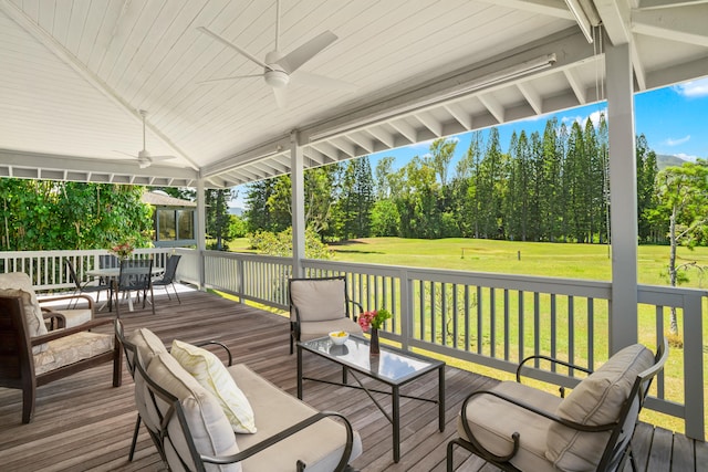 deck featuring outdoor dining space, outdoor lounge area, a ceiling fan, and a yard