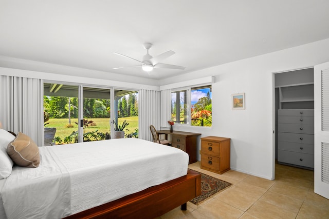 bedroom with access to exterior, light tile patterned floors, a spacious closet, a ceiling fan, and baseboards