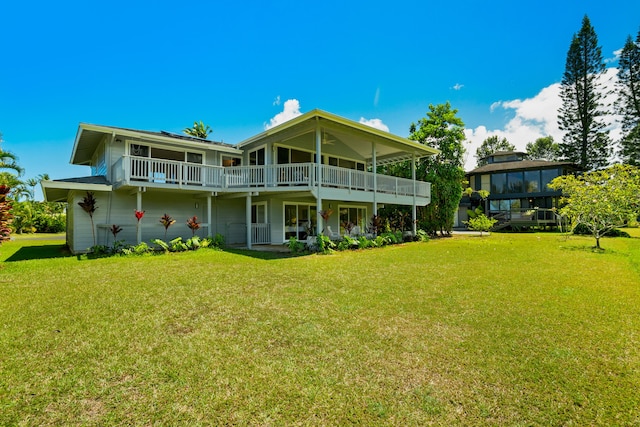 rear view of property with a deck and a yard