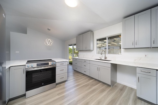 kitchen featuring lofted ceiling, sink, gray cabinetry, hanging light fixtures, and electric range