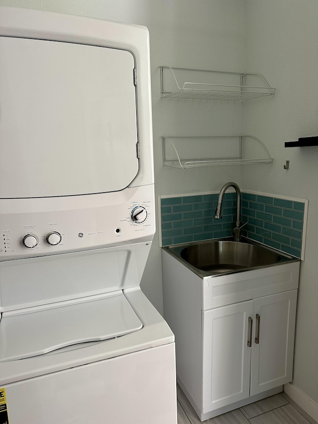 washroom featuring sink and stacked washer and clothes dryer