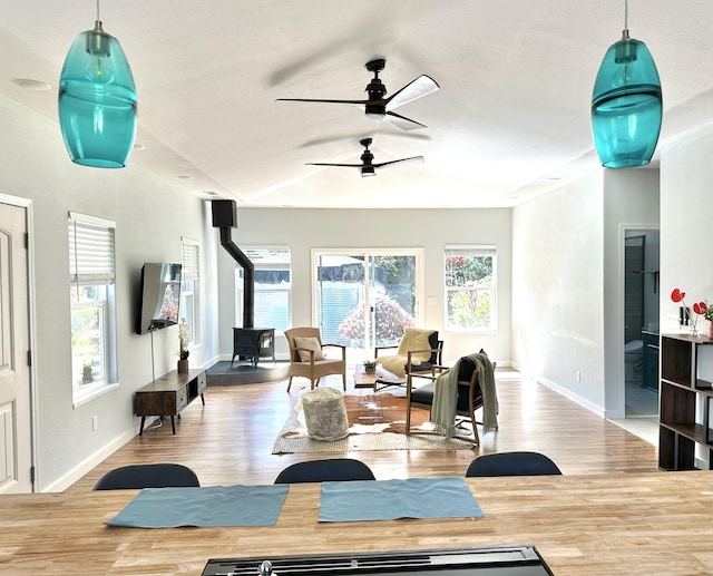 workout room with a wood stove, ceiling fan, and hardwood / wood-style flooring