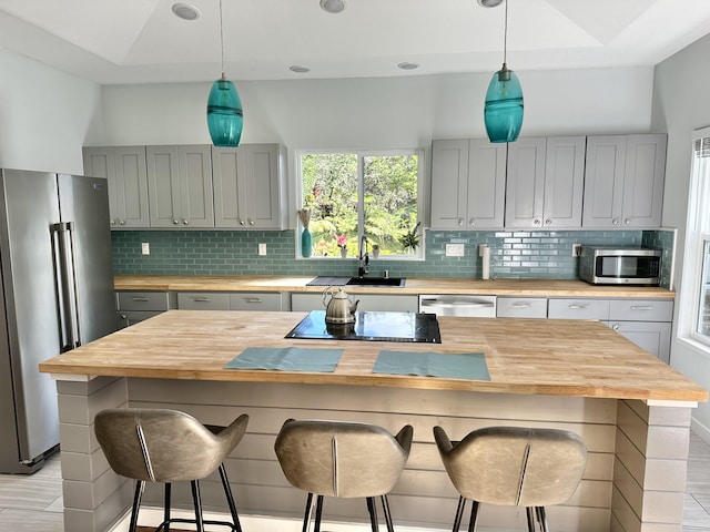 kitchen featuring sink, wood counters, a center island, and stainless steel appliances