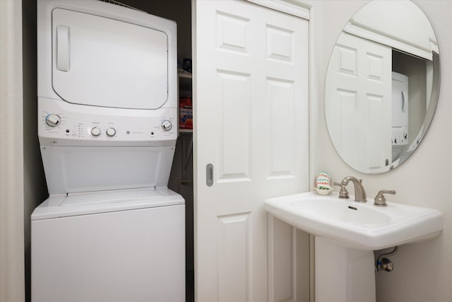 laundry area featuring stacked washer and dryer and sink