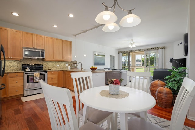 kitchen featuring sink, appliances with stainless steel finishes, dark hardwood / wood-style floors, decorative backsplash, and decorative light fixtures