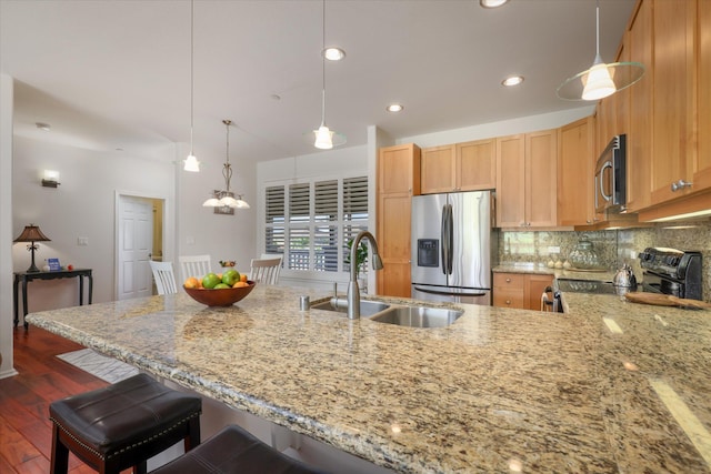 kitchen featuring appliances with stainless steel finishes, dark hardwood / wood-style floors, tasteful backsplash, sink, and kitchen peninsula