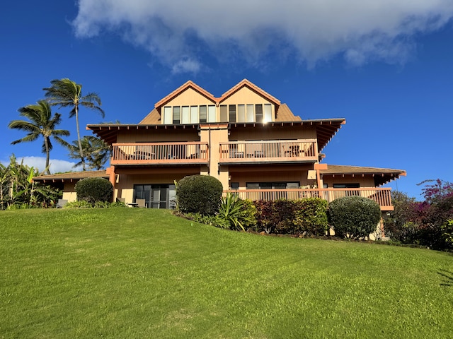 rear view of property featuring a lawn