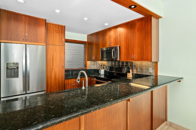 kitchen featuring light tile patterned floors, kitchen peninsula, stainless steel appliances, tasteful backsplash, and dark stone counters