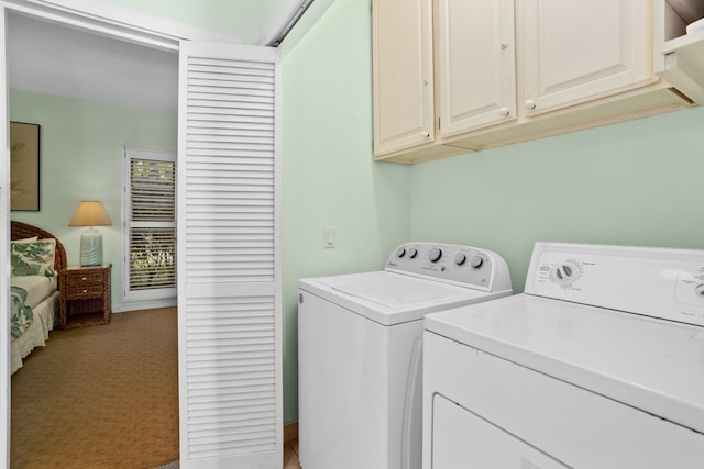 washroom with cabinets, light colored carpet, and separate washer and dryer