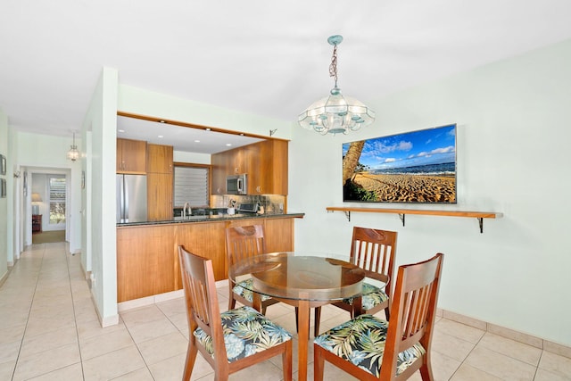 dining room featuring light tile patterned floors, sink, and a chandelier