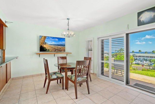 dining space featuring light tile patterned floors, plenty of natural light, and an inviting chandelier