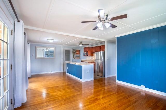 kitchen with a wealth of natural light, light hardwood / wood-style floors, and stainless steel fridge