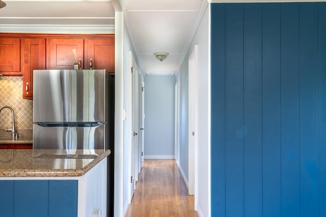 corridor featuring sink, crown molding, and light wood-type flooring