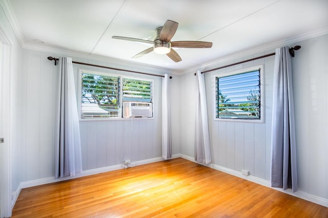 spare room featuring hardwood / wood-style flooring, cooling unit, ornamental molding, and ceiling fan