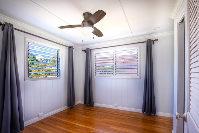 spare room featuring ceiling fan, wood-type flooring, and crown molding