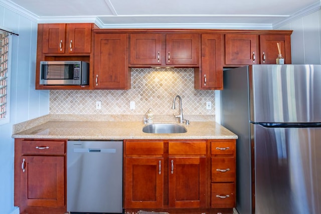 kitchen featuring light stone counters, sink, crown molding, and stainless steel appliances