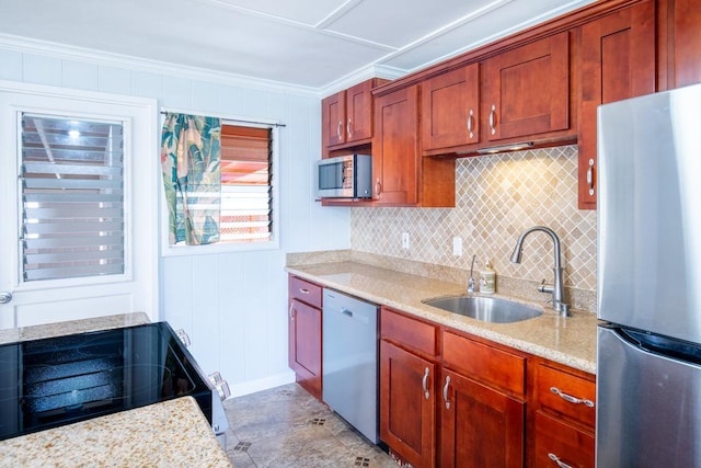 kitchen featuring light stone countertops, appliances with stainless steel finishes, sink, and ornamental molding