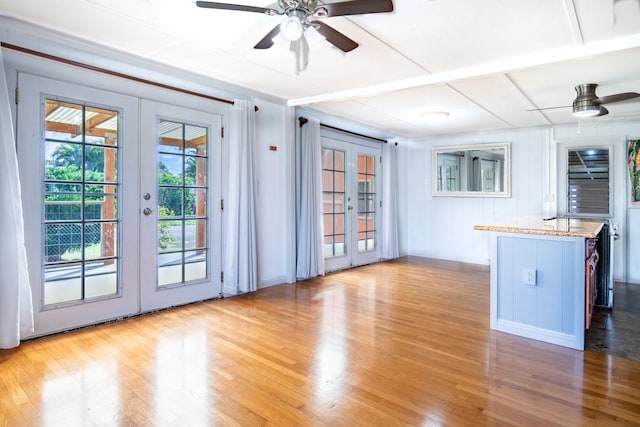 interior space with light wood-type flooring, french doors, and ceiling fan