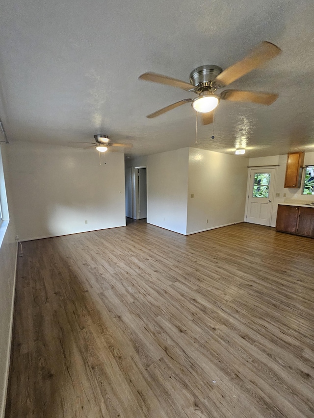 unfurnished living room featuring a textured ceiling, ceiling fan, and hardwood / wood-style flooring