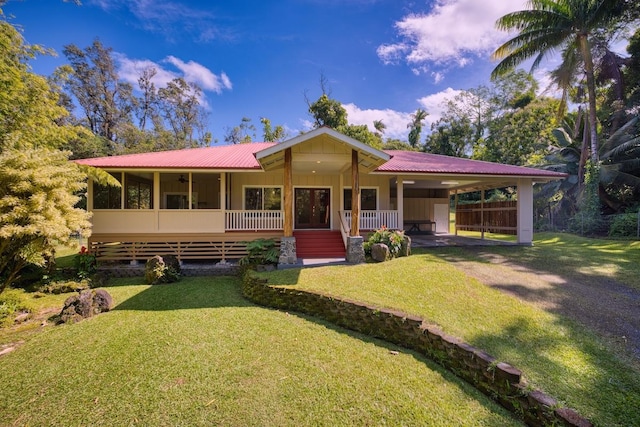 view of front of house with a carport, a sunroom, and a front lawn