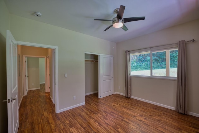 unfurnished bedroom with dark wood-type flooring, ceiling fan, and a closet