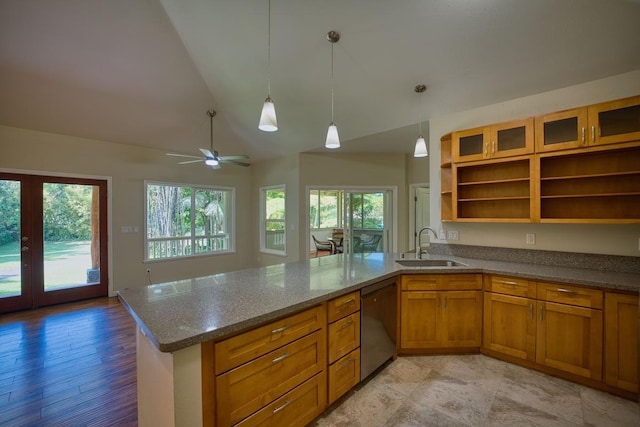 kitchen featuring sink, light stone counters, vaulted ceiling, dishwashing machine, and kitchen peninsula