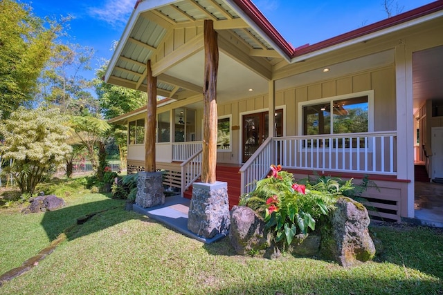 doorway to property featuring a porch and a yard